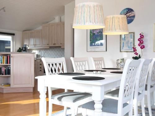 a white dining room with a white table and white chairs at 8 person holiday home in V ggerl se in Marielyst