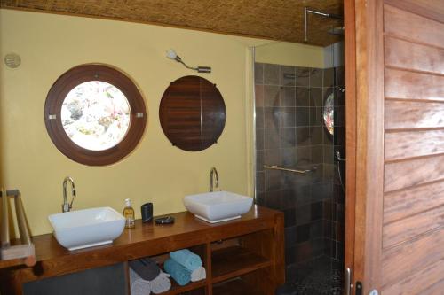 ein Bad mit 2 Waschbecken und einer Dusche in der Unterkunft Villa atypique le chat perché de Grand Anse in Petite Île