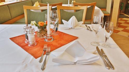 a table with a white table cloth with candles and wine glasses at Businesshotel HEILBRONN- Biberach in Heilbronn