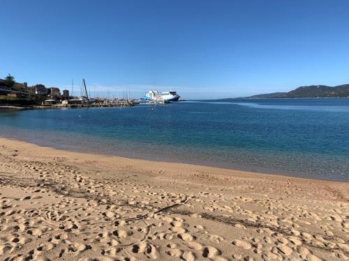 a sandy beach with a boat in the water at T3 vue mer in Propriano