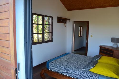 a bedroom with a bed and a window at Villa atypique le chat perché de Grand Anse in Petite Île