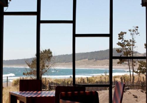 a view of a beach from a window at Hotel Punta Sirena in Curanipe