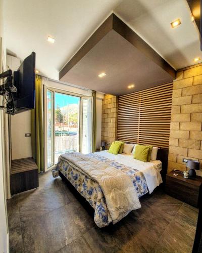 a bedroom with a large bed and a large window at Mongibello Palace B&B in Mondello