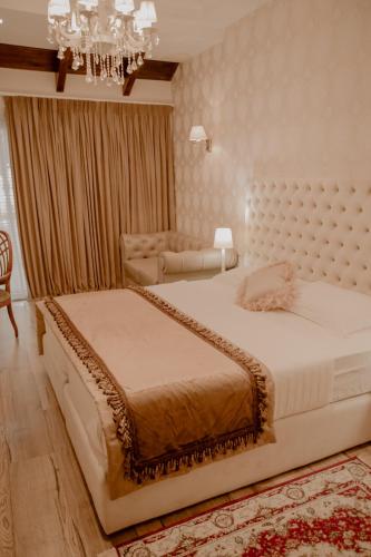 a bedroom with two beds and a chandelier at Green House Hotel & Restaurant in Tirana