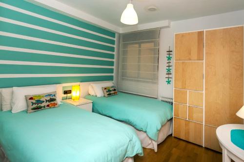 コラレホにあるCasa ANA Corralejoの青と白のストライプを用いた客室のベッド2台