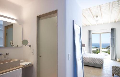 a white bathroom with a view of a bedroom at ABSOLUTE PARADISE in Paradise Beach