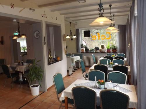 Pension Sonneneck في Kamschlacken: مطعم فيه طاولات وكراسي في الغرفة