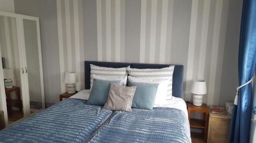 a blue and white bed with blue and white pillows at Baltica Towers AP1108 apartament studio in Gdańsk