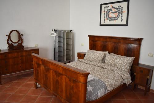 1 dormitorio con cama de madera y espejo en VILLA CLANI apartment en Colà di Lazise