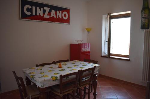 a dining room with a table and chairs and a sign at VILLA CLANI apartment in Colà di Lazise