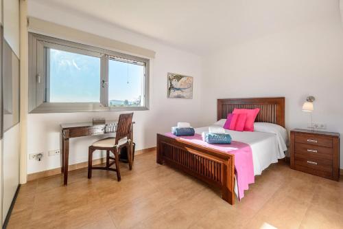 a bedroom with a bed and a desk and a window at Villa Can Vinyes in Santa Gertrudis de Fruitera