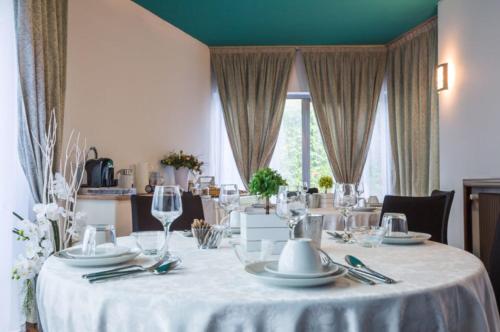 a dining table with a white tablecloth and wine glasses at Villa Berrettini in Marano Vicentino