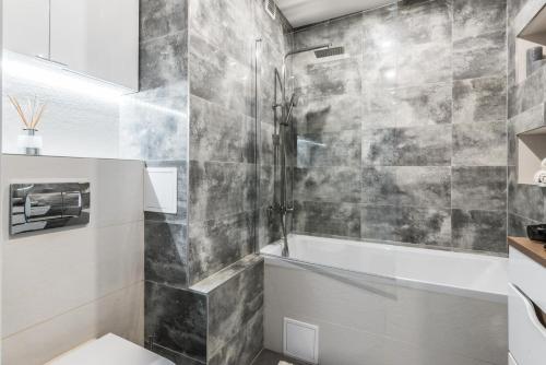 a bathroom with a shower and a toilet and a tub at Theatre Apartment - Apartament przy Rynku w Głogowie in Głogów