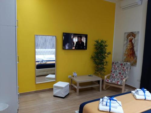 a yellow room with two beds and a mirror at Red House in Naples
