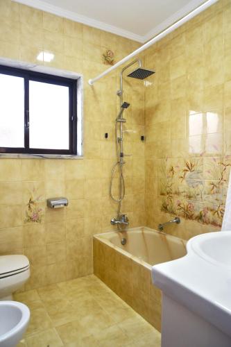 a bathroom with a tub and a toilet and a sink at Encarnação Home in Lisbon