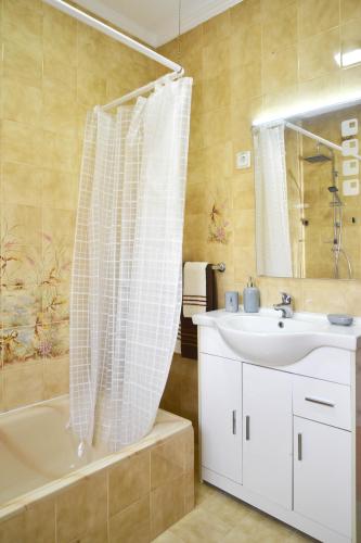 a bathroom with a tub and a sink and a shower at Encarnação Home in Lisbon
