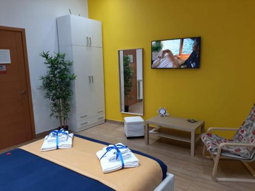 ナポリにあるRed Houseのベッド1台と壁掛けテレビが備わる客室です。