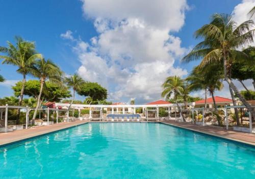 a pool at a resort with palm trees at Apartamento Familiar Vacaciones en Curacao in Jan Thiel