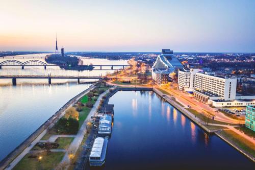 Blick auf eine Stadt mit Fluss und Gebäuden in der Unterkunft Radisson Blu Daugava Hotel, Riga in Riga