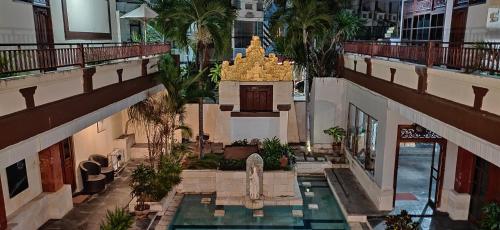 an overhead view of a building with a pool and a fountain at Hana Kuta Beach Hotel in Kuta