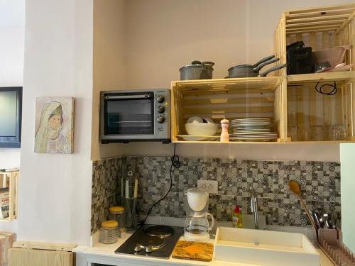 a kitchen with a microwave and a counter top at Jardin de bougainvillier in Sfax