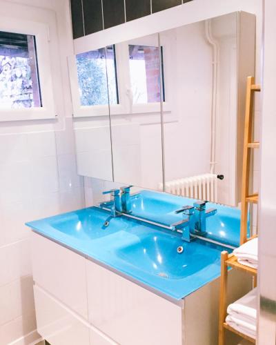 une salle de bain avec un lavabo bleu et des armoires blanches dans l'établissement La Closerie Saint Rémy, à Hautot-sur-Mer