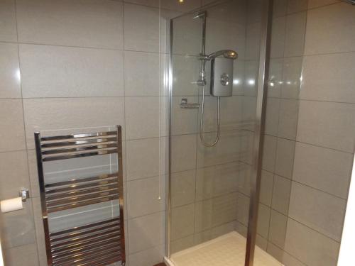 um chuveiro numa casa de banho com uma porta de vidro em The Griffin Inn em Halifax