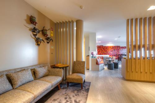 a living room with a couch and a table and chairs at Hotel Spot Family Suites in Porto