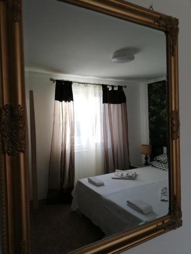 a mirror reflection of a bed in a room at Hotel Hobby in Hunedoara