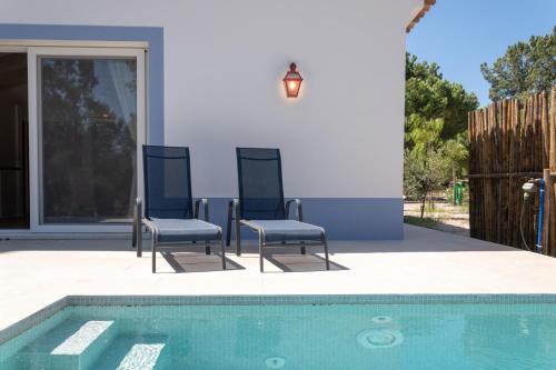 due sedie sedute accanto a una piscina di Casas da Horta ad Alcácer do Sal
