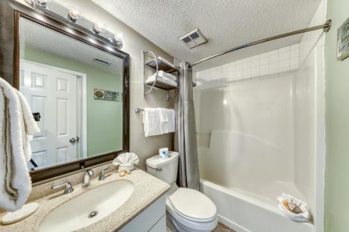 a bathroom with a sink and a toilet and a mirror at Tidewater II in Orange Beach