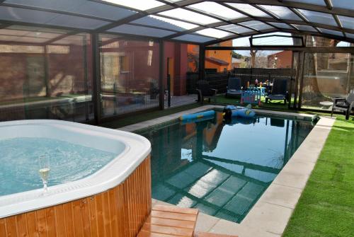 una piscina con bañera de hidromasaje en una casa en Casa Rural Mansion Alejandra con piscina y jacuzzi en Collado Mediano