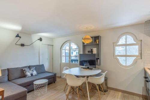 uma sala de estar com um sofá, uma mesa e cadeiras em Appartement Odyssée - Welkeys em Megève