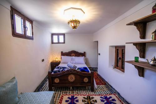 um quarto com uma cama e um lustre em Apartment Lala Rkia em Fez