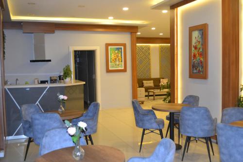 a waiting room with blue chairs and tables at Almasa Suite Aparts in Termal