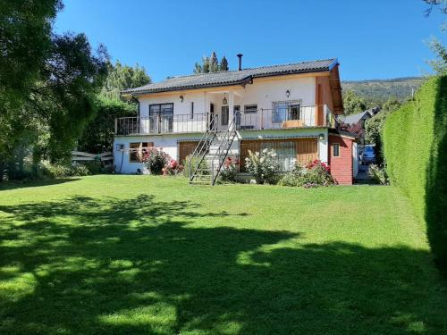 una casa grande con césped delante en Don Alfonso Departamento, en San Carlos de Bariloche