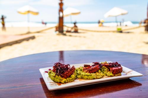 een bord eten op een tafel naast het strand bij Del Wawa in Máncora