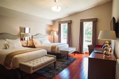 Habitación de hotel con 2 camas, mesa y sillas en Atiq Boutique Hotel, en Cusco