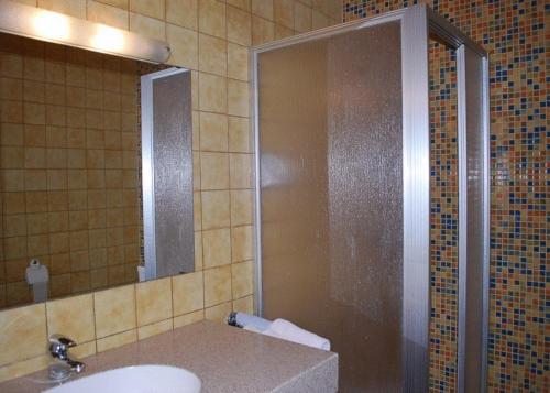 a bathroom with a shower and a sink and a mirror at Angerhof in Dorfstetten