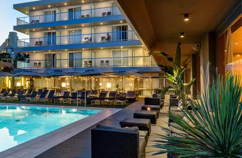 a hotel with a pool and chairs and a building at Astari in Tarragona