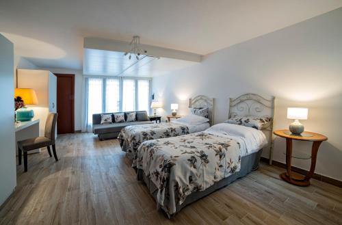 a bedroom with two beds and a couch at B&B Sant'Erasmo in Santeramo in Colle