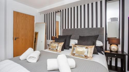 a bedroom with a large bed with black and white pillows at The Abbots Chambers in York