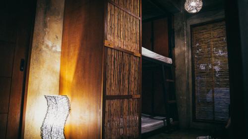 a room with a wooden wall with a lamp at Hang Loose Hostel in General Luna