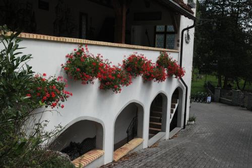 a building with red flowers on the side of it at la Cibourg, Centre de vacances in Renan