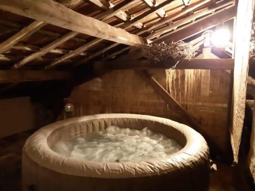 a large tub filled with water in a building at Gîte, jacuzzi & vin au grenier de Madiran in Madiran