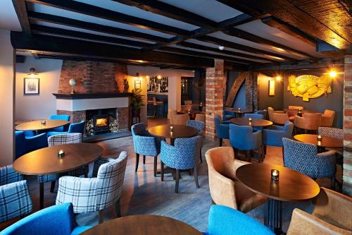 a restaurant with tables and chairs and a fireplace at The Merchant's House, BW Signature Collection in Salisbury