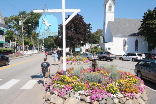 a man walking down a street next to a cross at Sea Chambers in Ogunquit