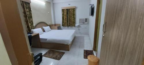 a bedroom with a bed and a room with a television at Hotel Fortune in Patna