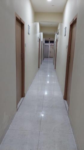 an empty hallway with doors and a long corridor at Hotel Fortune in Patna
