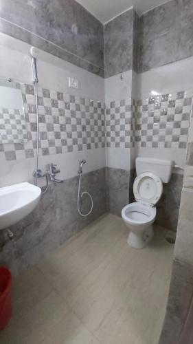 a bathroom with a toilet and a sink at Hotel Fortune in Patna